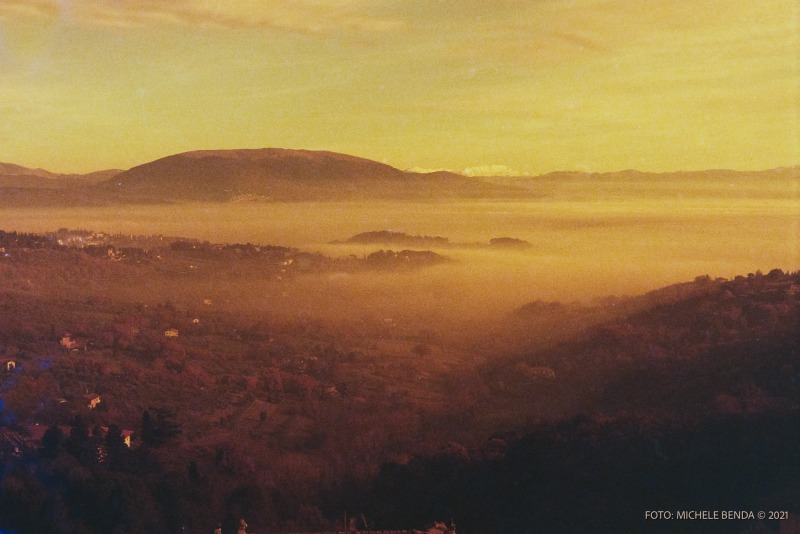 Vista sulla Valle Umbra nascosta dalla nebbia, sullo sfondo il Monte Subasio ed in lontananza il Monte Vettore innevato. durante Perugia fotografata con pellicola Lomography RedScale Xr 50-200. Foto di Michele Benda. Gennaio 2021 presso Palazzo del Capitano del Popolo Perugia IT, 22 febbraio 2021. Foto: Michele Benda per VolleyFoto.it [riferimento file: 2021-02-22/_7505964]